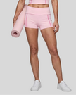 Lower body front view of woman wearing TrackLine Yoga Shorts in pink
