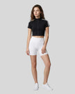 Angled front view of the Athlesi TrackLine Zip Crop Tee in black with contrast stripe sleeve details