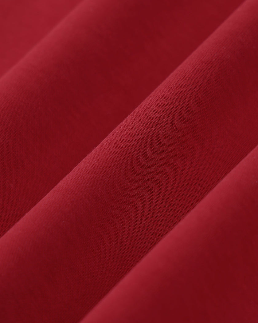 Closeup of the soft stretch fabric texture on the Athlesi TrackLine Zip Crop Tee in red