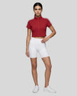 Woman wearing the Athlesi TrackLine Zip Crop Tee in red styled in a modern minimalist setting
