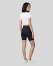 Back view of the Athlesi TrackLine Zip Crop Tee in white styled with a sport-inspired minimalist look
