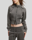 Angled front view of woman wearing cropped Vintage Washed Edition Hoodie with contoured seam details in Dark Gray