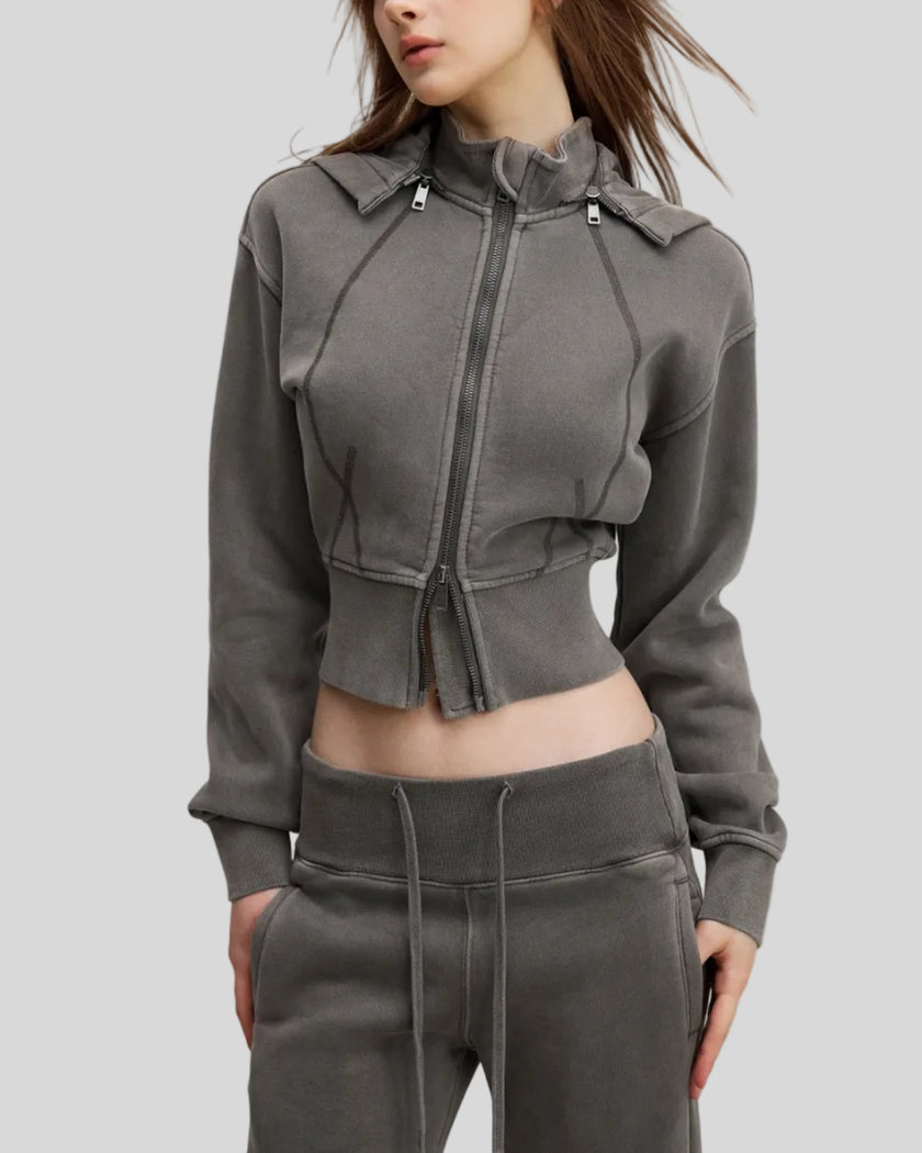 Angled front view of woman wearing cropped Vintage Washed Edition Hoodie with contoured seam details in Dark Gray