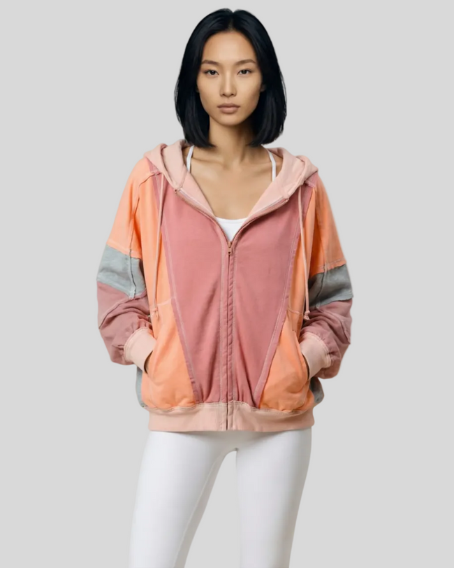 Model wearing the AuraShift Colorblock Hoodie in burnt coral, styled with Athlesi leggings
