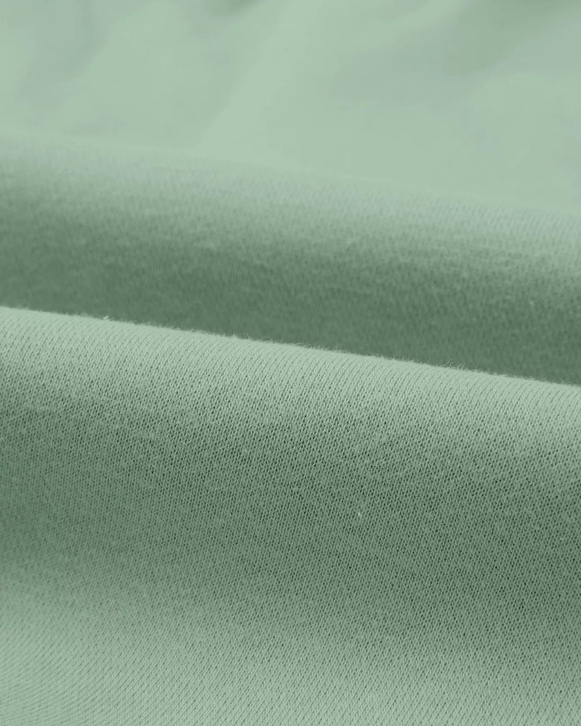 Close-up of midweight knit fabric texture on UrbanFlow set in sage