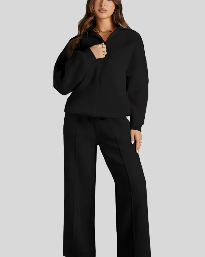 Front view of UrbanFlow zip jacket fully zipped with matching pants in black