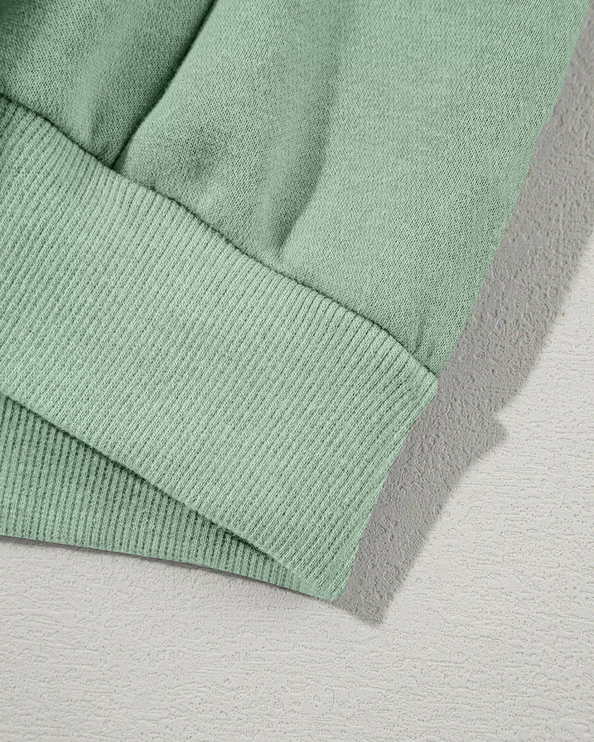 Jacket waistband close-up showing relaxed hem structure in sage